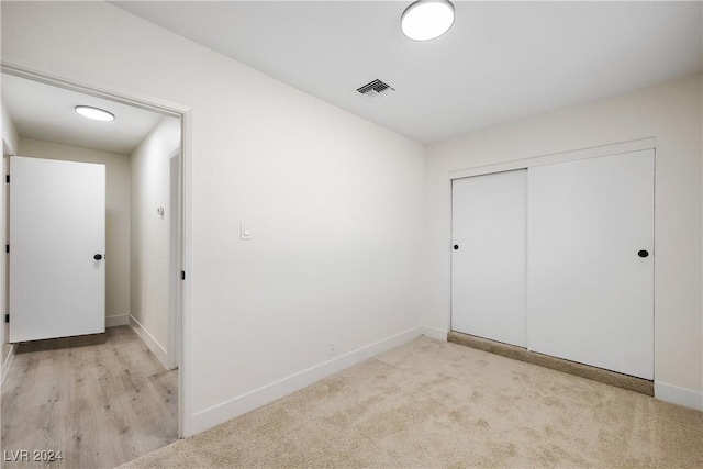 unfurnished bedroom featuring light hardwood / wood-style flooring and a closet