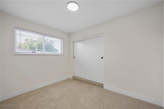 unfurnished room featuring light colored carpet