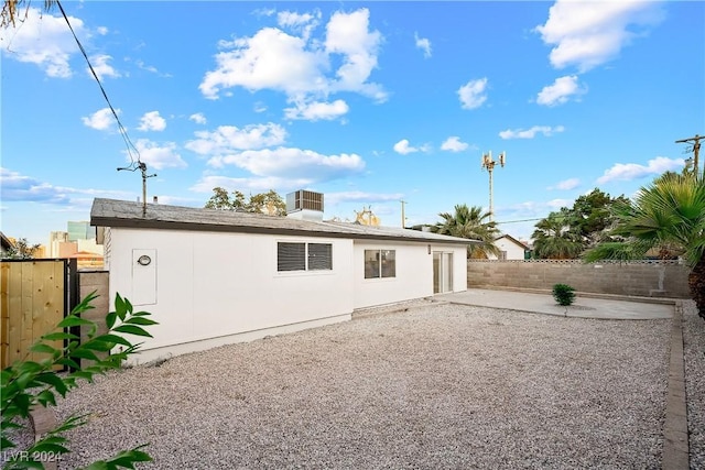 back of property with central air condition unit and a patio