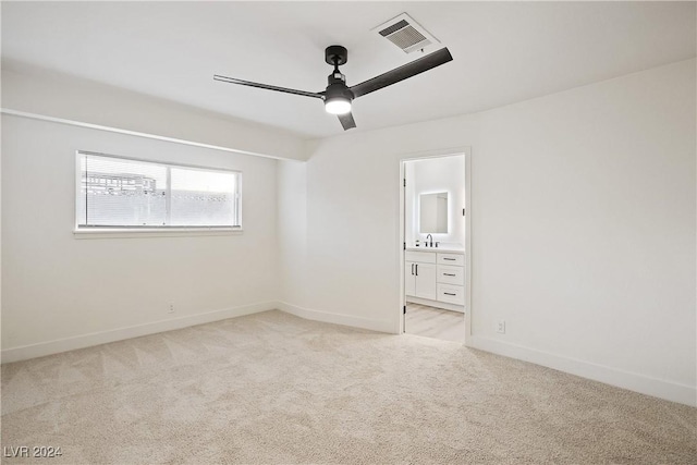 carpeted spare room featuring ceiling fan and sink