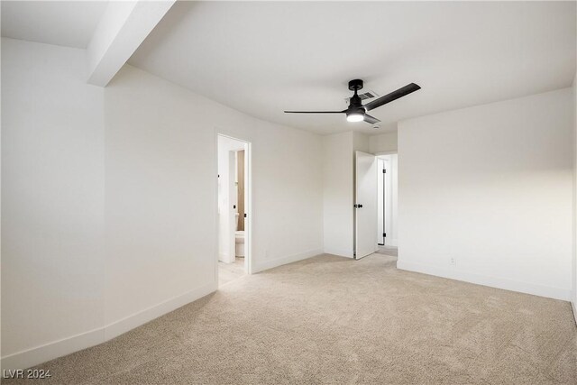 empty room featuring ceiling fan and light colored carpet