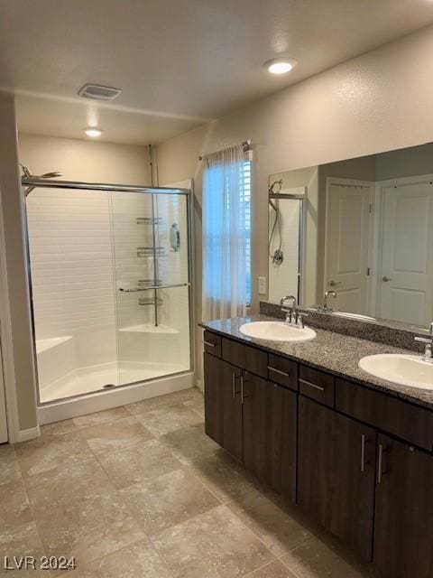 bathroom with vanity and a shower with door