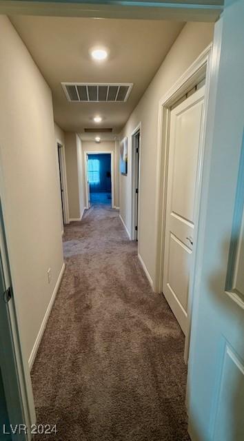 hallway featuring dark carpet