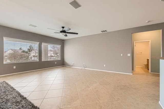 empty room with ceiling fan and light tile patterned flooring