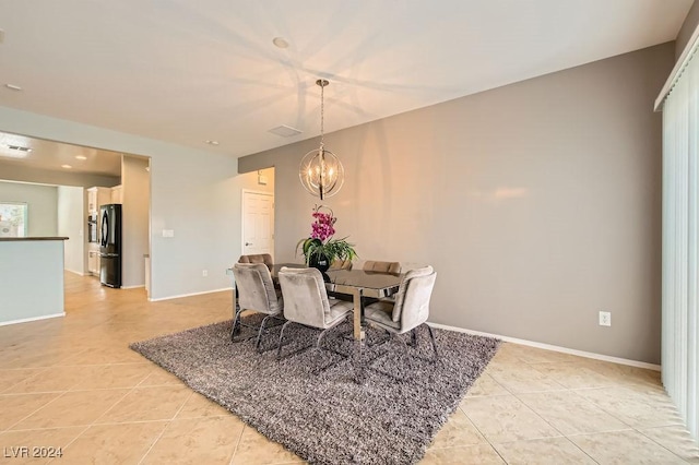 tiled dining room featuring an inviting chandelier