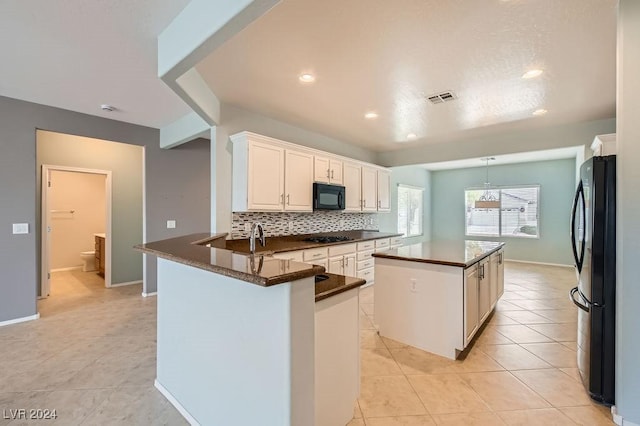 kitchen featuring black appliances, kitchen peninsula, light tile patterned floors, a kitchen island, and white cabinetry