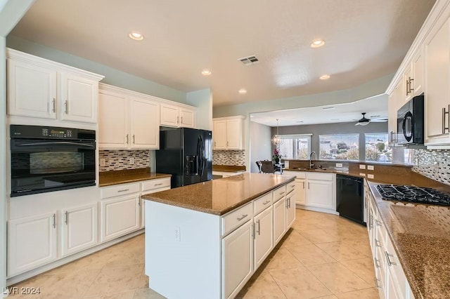 kitchen with black appliances, a center island, white cabinetry, and sink