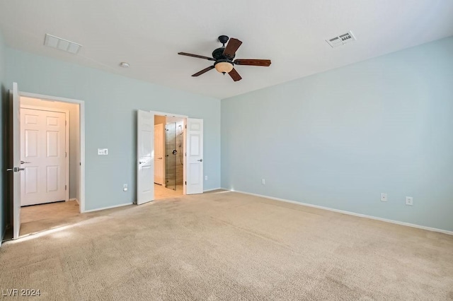 unfurnished bedroom with light colored carpet, ensuite bath, and ceiling fan