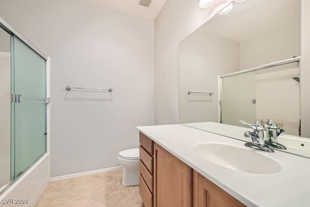 full bathroom with vanity, toilet, and bath / shower combo with glass door