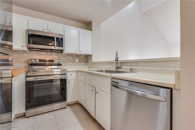 kitchen with backsplash, sink, white cabinets, and stainless steel appliances