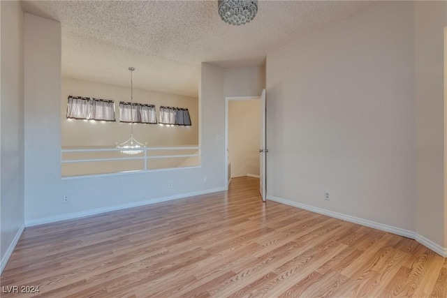 unfurnished dining area featuring light hardwood / wood-style floors and a textured ceiling