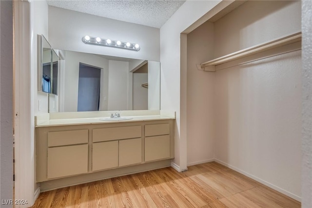 bathroom with vanity, a textured ceiling, and hardwood / wood-style flooring