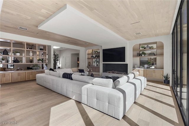 living room with built in features, light wood-type flooring, wood ceiling, and visible vents