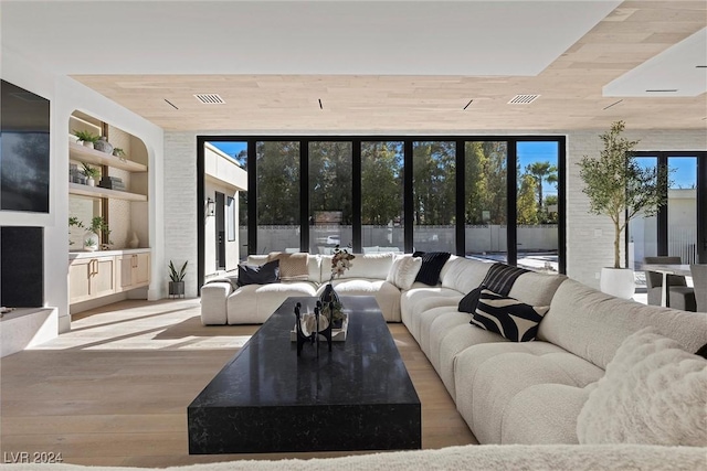 living area with wooden ceiling, built in shelves, and wood finished floors