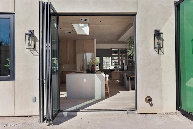 entrance to property featuring visible vents and stucco siding