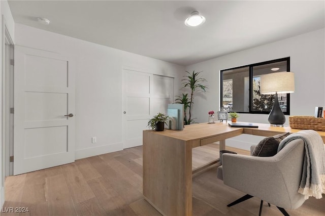 office area featuring light wood-style flooring and baseboards