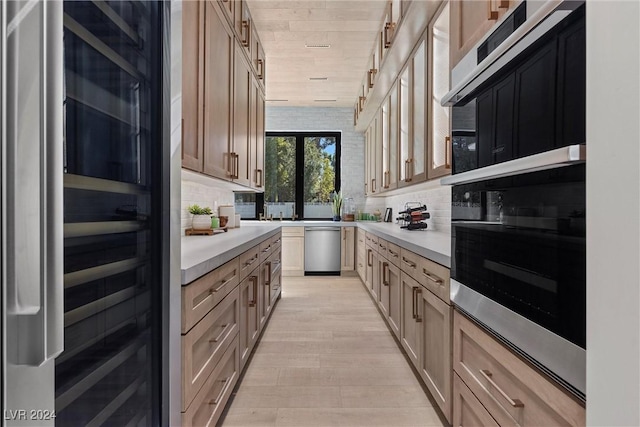 kitchen with tasteful backsplash, wine cooler, stainless steel appliances, and light countertops