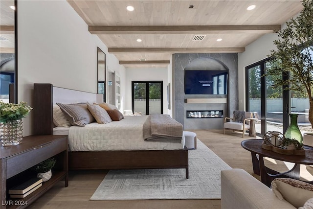 bedroom featuring wood ceiling, wood finished floors, a fireplace, beam ceiling, and recessed lighting