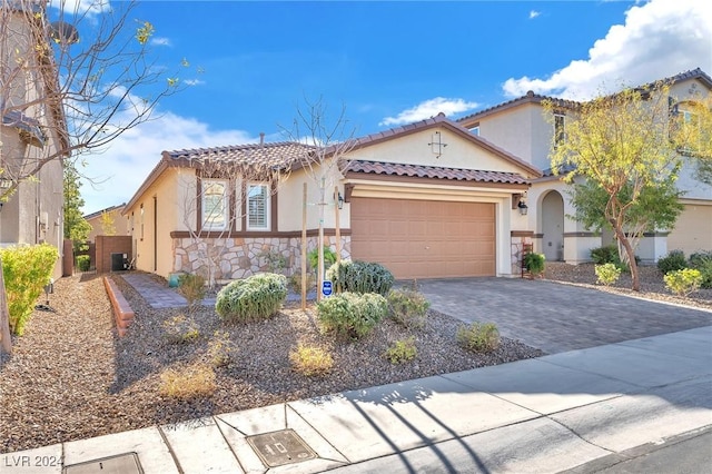 mediterranean / spanish house featuring a garage and central AC