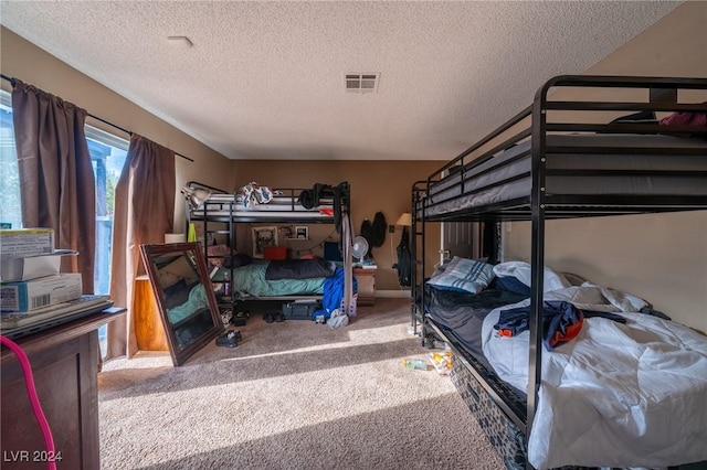 bedroom with carpet floors and a textured ceiling