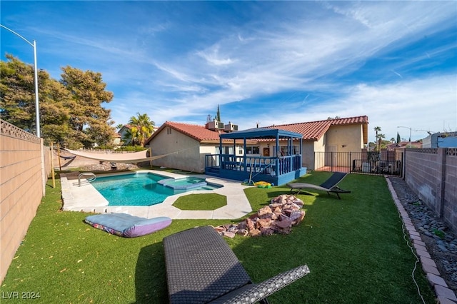 view of pool with a gazebo, an in ground hot tub, a lawn, and a deck