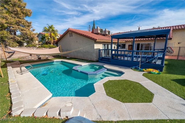 view of pool with an in ground hot tub, central AC unit, a lawn, and a wooden deck