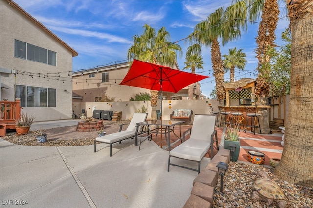 view of patio with exterior bar and a fire pit