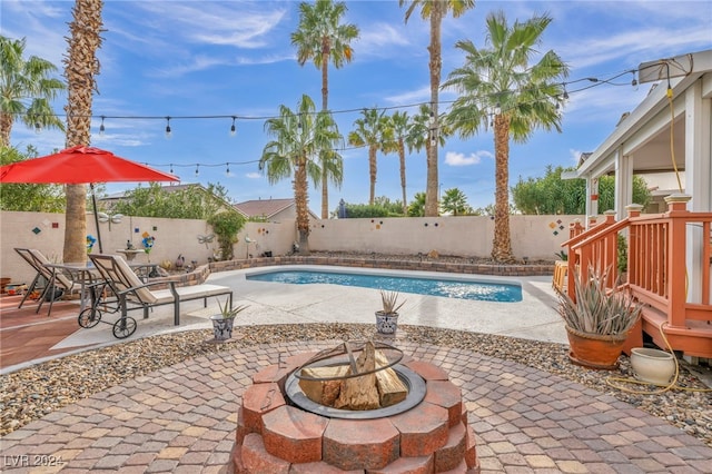 view of swimming pool featuring a fire pit and a patio