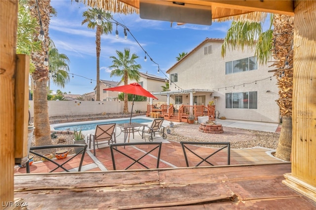 view of patio / terrace with an outdoor fire pit and a swimming pool side deck