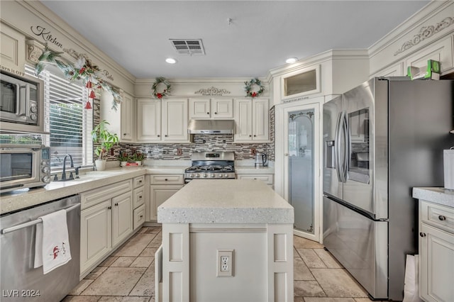 kitchen featuring sink, stainless steel appliances, a center island, and backsplash