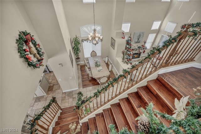 stairway with a high ceiling and an inviting chandelier