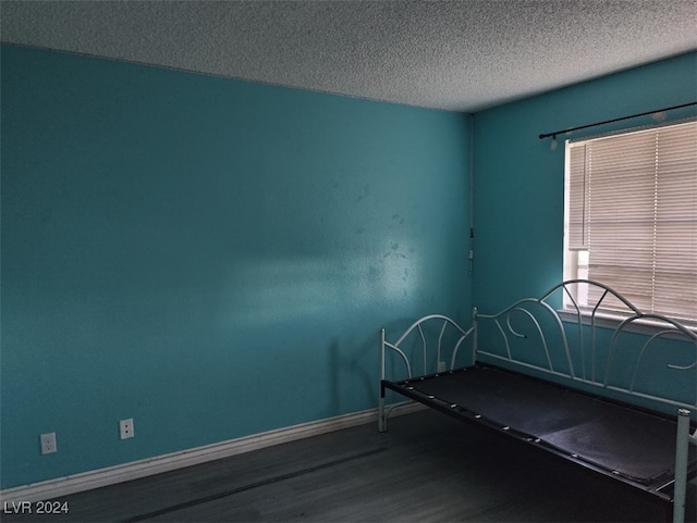 unfurnished bedroom featuring a textured ceiling and hardwood / wood-style flooring