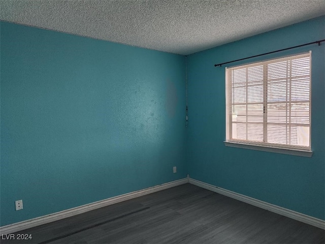 unfurnished room with wood-type flooring and a textured ceiling