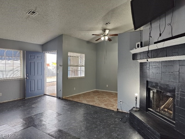 unfurnished living room featuring a fireplace, a textured ceiling, ceiling fan, and lofted ceiling