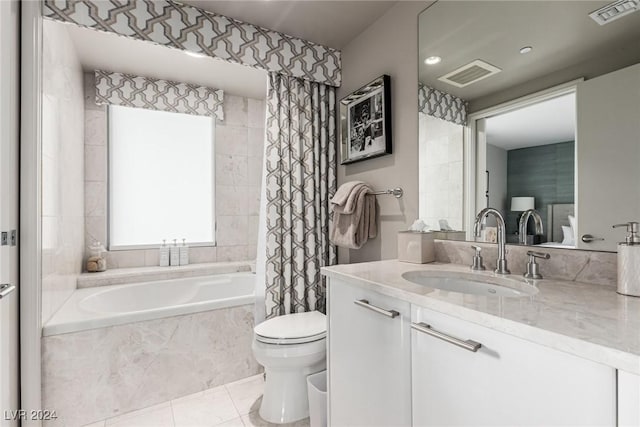 bathroom with tile patterned flooring, vanity, toilet, and tiled tub