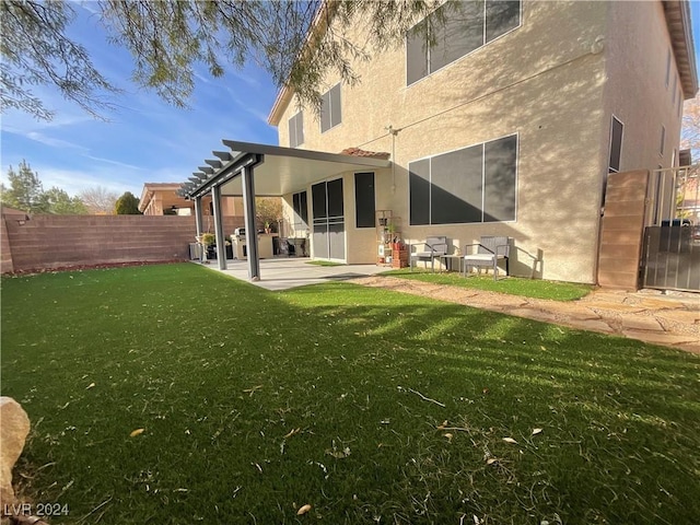 rear view of house with a patio and a lawn