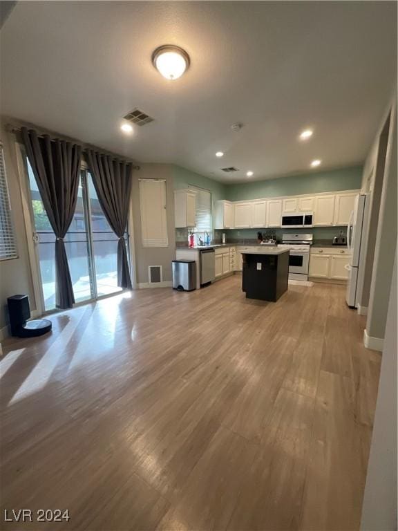 kitchen featuring a center island, white cabinets, light hardwood / wood-style floors, and appliances with stainless steel finishes