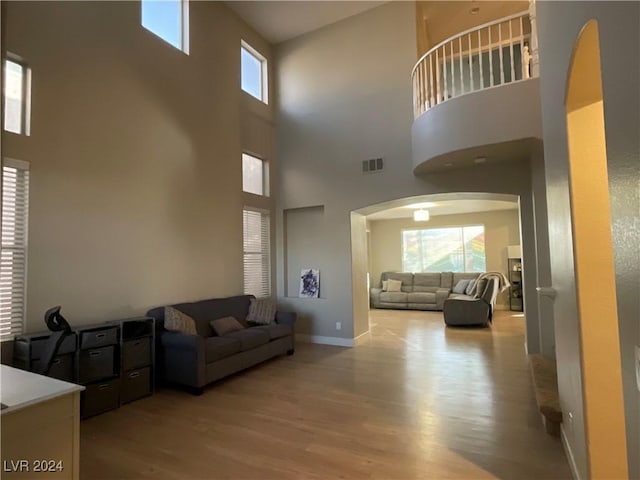 living room with a high ceiling and light hardwood / wood-style flooring