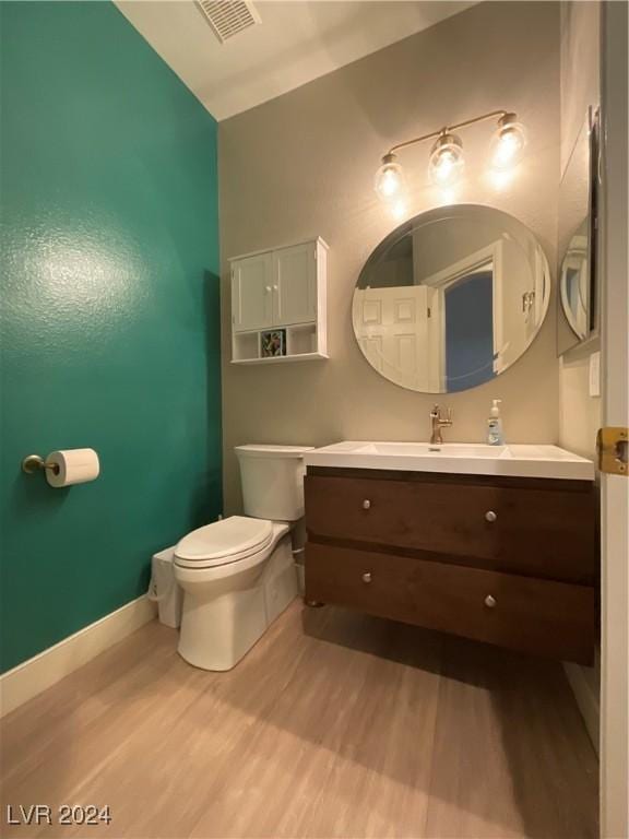 bathroom featuring hardwood / wood-style flooring, vanity, and toilet