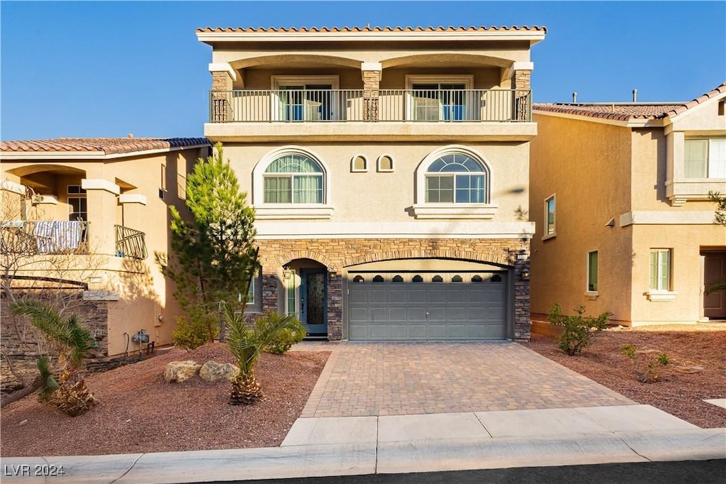 mediterranean / spanish house featuring a garage and a balcony