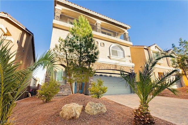 mediterranean / spanish-style house featuring a garage and a balcony