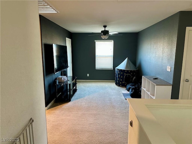 interior space with light carpet and ceiling fan