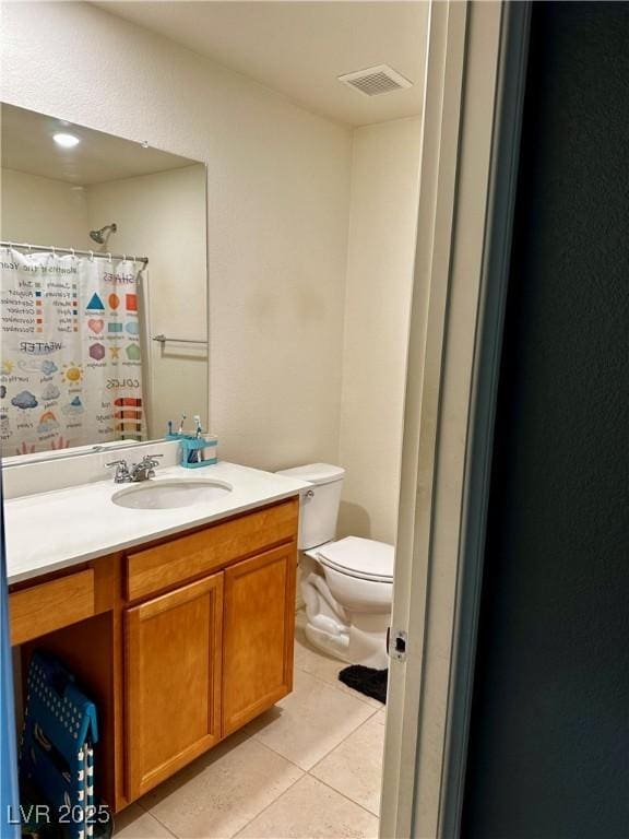 bathroom featuring tile patterned floors, vanity, and toilet