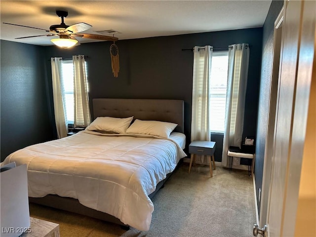 bedroom featuring ceiling fan, multiple windows, and carpet flooring