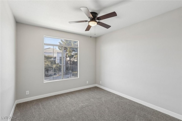 carpeted empty room with a ceiling fan and baseboards