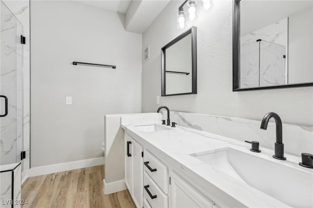 bathroom featuring visible vents, wood finished floors, a sink, and a marble finish shower