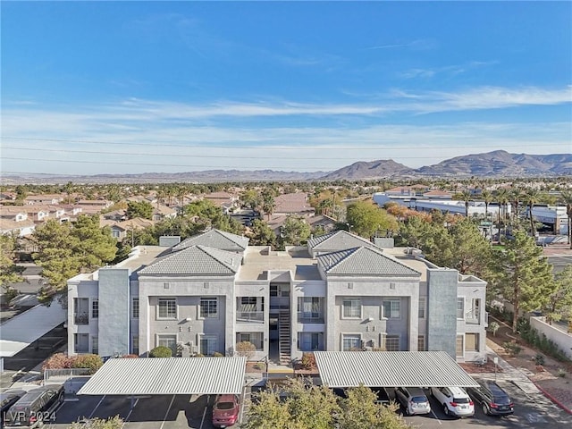 exterior space with a residential view, a mountain view, uncovered parking, and stucco siding