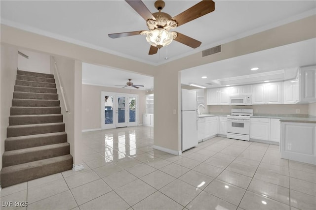 kitchen with sink, white cabinets, light tile patterned floors, crown molding, and white appliances