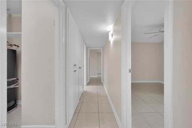 hallway with water heater and light tile patterned floors