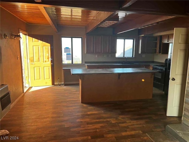 kitchen with dark wood-type flooring, black range, sink, beamed ceiling, and heating unit